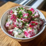 Nahaufnahme eines weißen Schälchens mit cremigem Radieschen-Dip, garniert mit frischem Schnittlauch.