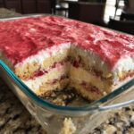 Anschnitt eines cremigen Erdbeer Tiramisu in einer Glasform mit sichtbaren Schichten aus Biskuit und Erdbeeren.
