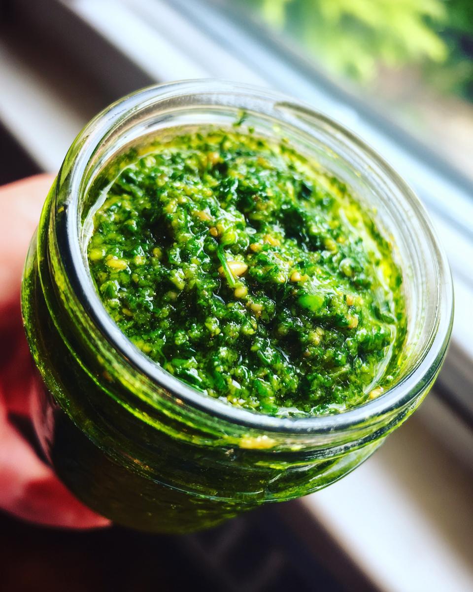 Nahaufnahme von leuchtend grünem Bärlauchpesto, gefüllt in einem Glas, bereit zur Lagerung.