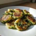 Goldbraun gebratene Bärlauchgnocchi, angerichtet auf einem weißen Teller, mit sichtbaren grünen Bärlauchstückchen.