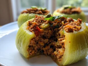Nahaufnahme von drei Gefüllte Kohlrabi, einer davon angeschnitten, gefüllt mit würziger Hackfleischmasse.