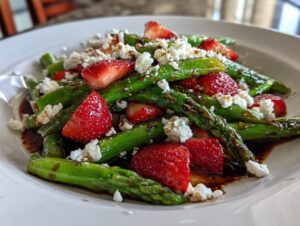Nahaufnahme eines Spargelsalat mit Erdbeeren, zerbröseltem Feta und Balsamico-Dressing.