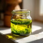 Grünes Bärlauch-Pesto schwimmt in gelbem Öl in einem kleinen Glas zur Konservierung.