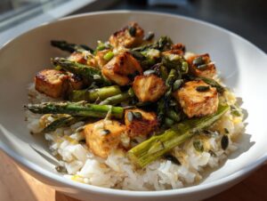Nahaufnahme einer fertigen Spargel-Reis-Bowl mit gebratenem Tofu, grünem Spargel und Kürbiskernen.