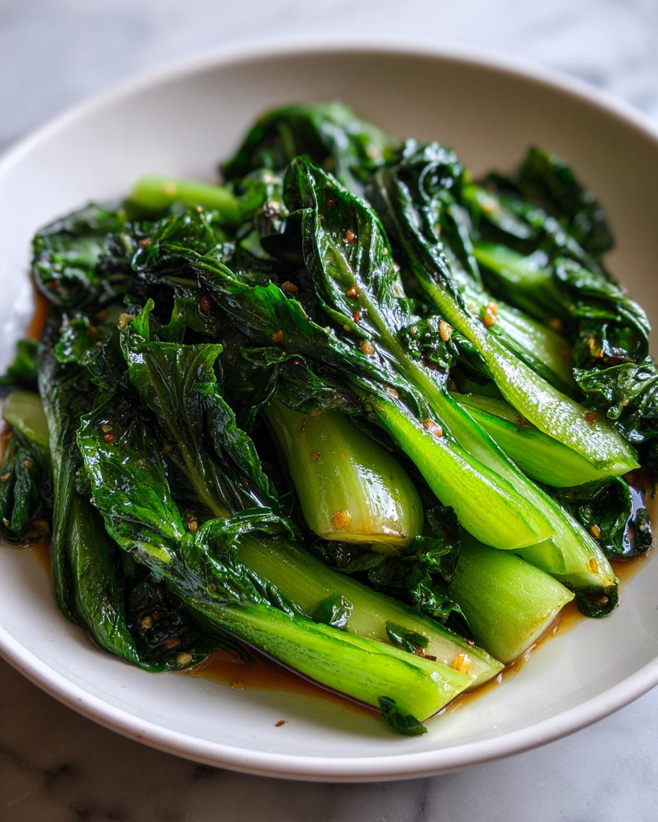 Nahaufnahme von saftigem, gebratenem Pak Choi in der Pfanne, glasiert mit dunkler Soße.