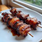 Zwei saftige Grillfackeln mit glasiertem Fleisch auf einem weißen Teller, ideal für Grillfackeln Rezepte.