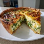 Nahaufnahme einer angeschnittenen Knusprige Spargelquiche mit goldbraun gebackener Kruste und cremiger Füllung.