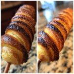 Nahaufnahme von goldbraun gebackenem Stockbrot vom Lagerfeuer, spiralförmig um einen Holzspieß gewickelt.