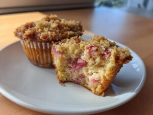 Nahaufnahme von aufgeschnittenen Rhabarber-Muffins mit saftigem Inneren und knusprigen Streuseln.